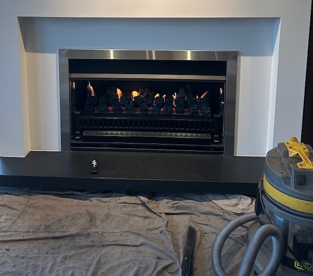 Gas fire being serviced, drop sheet and vaccuum